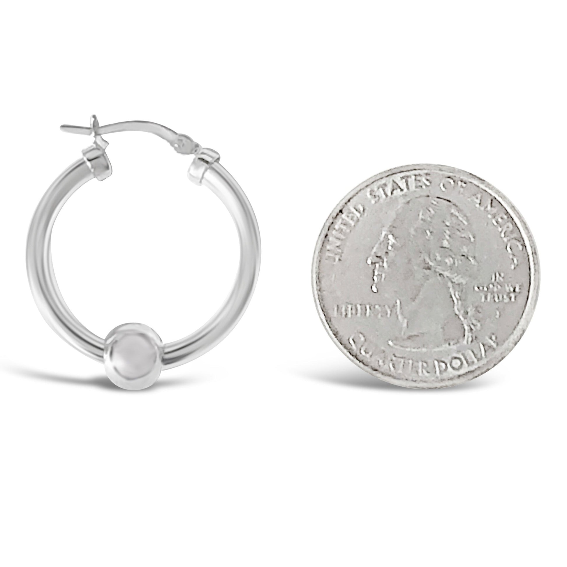 Cape cod hoop earrings measuring against a quarter